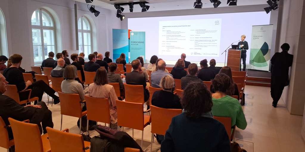 Blick auf die Bühne beim Jahresforum Zivilgesellschaftsdaten Vorne steht der Leiter von Ziviz, Peter Schubert.