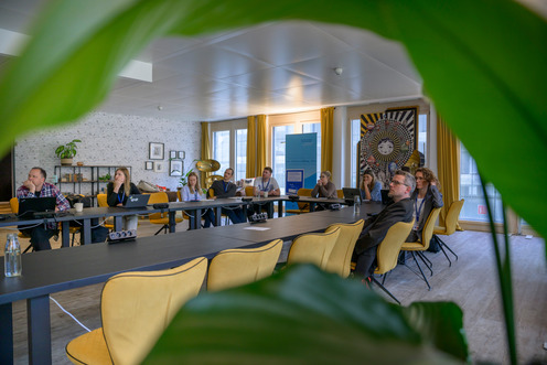 Mehrere Menschen sitzen an einem großen Tisch.